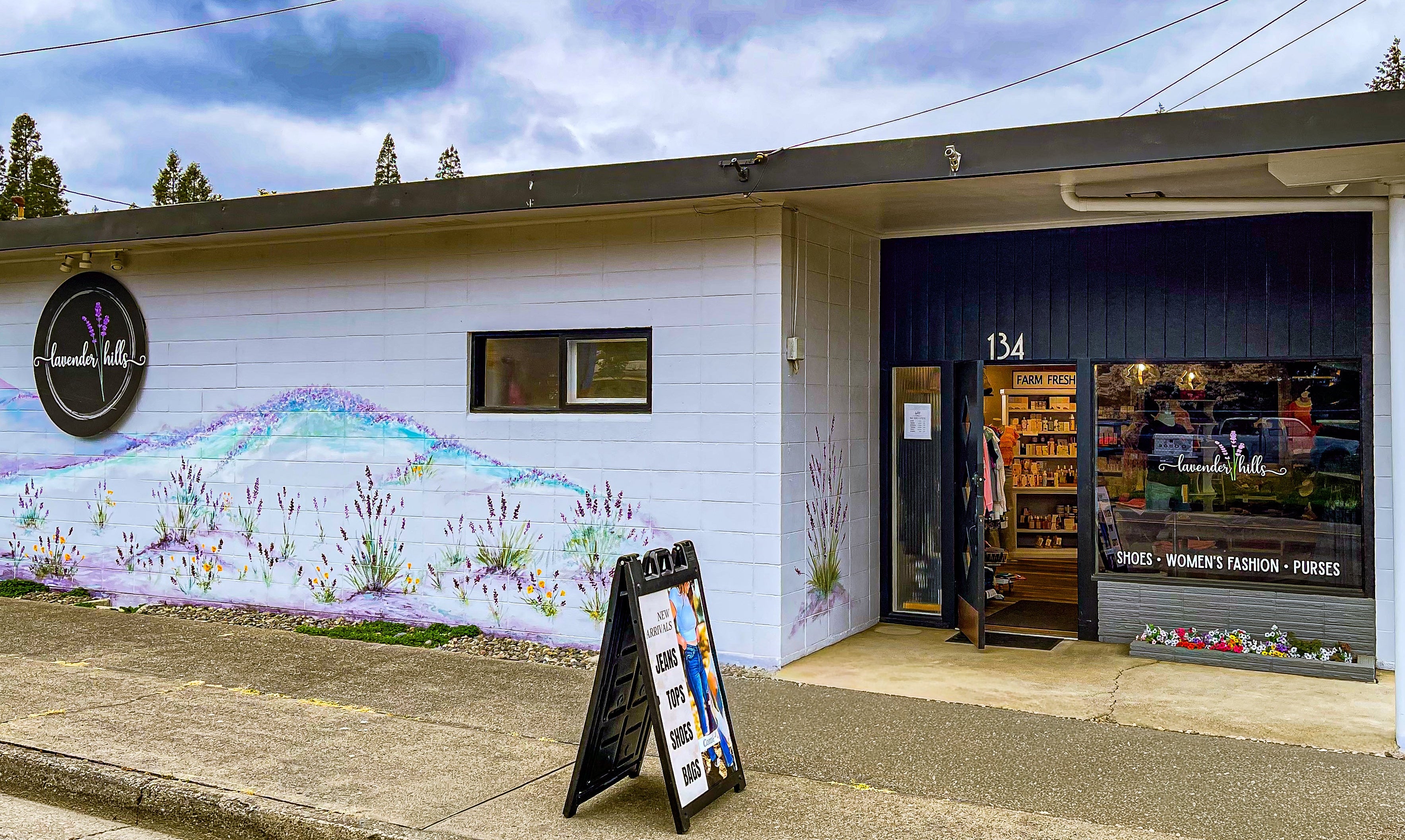 Storefront with a mural on the wall and a sign in front